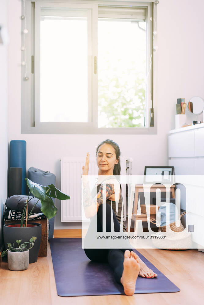 Mid adult woman practicing yoga at home model released Symbolfoto property released DAMF00868