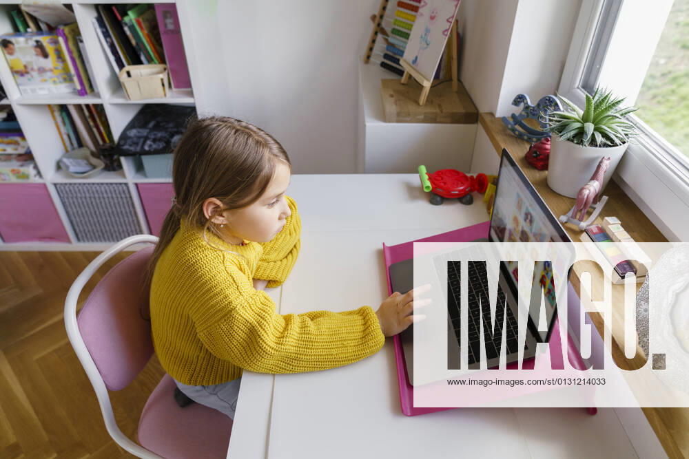 Girl using laptop on desk while learning at home model released Symbolfoto property released KMKF01720