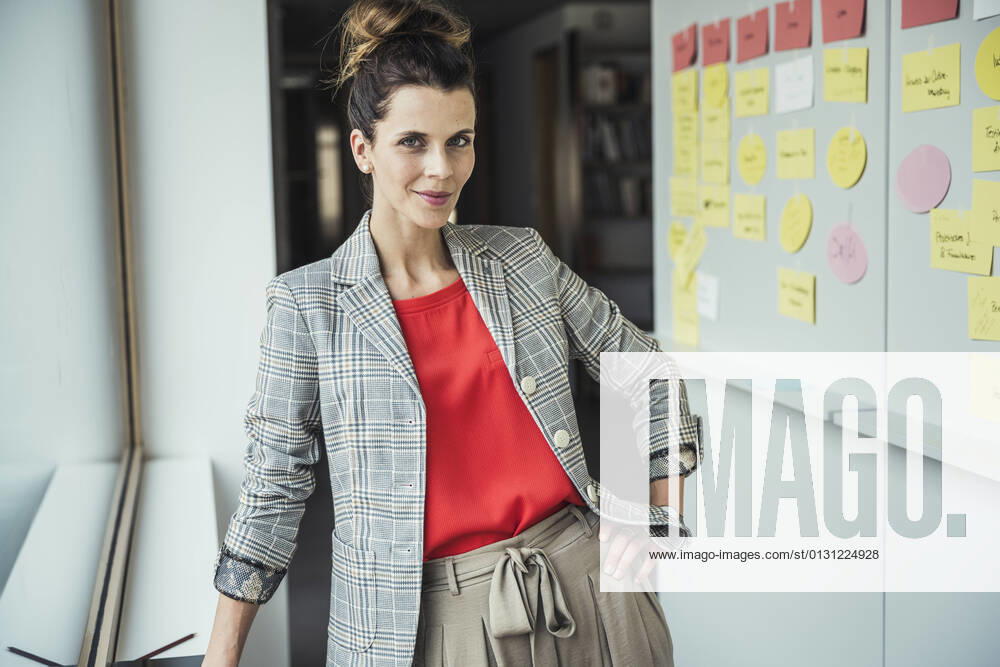 IMAGO Creative: Internationaler Frauenmonat, Geschlechterrollen aufbrechen Businesswoman with hand on hip standing in office model released Symbolfoto property released UUF24426