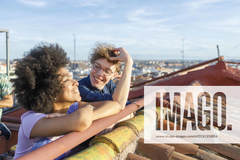 IMAGO Creative, Jahreszeit Sommer, Sommer in der Stadt Smiling friend looking at female friend on terrace model released Symbolfoto property released IFRF01045