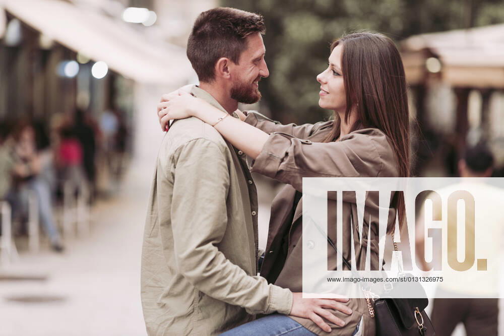 Smiling woman with arm around looking at boyfriend model released Symbolfoto LJF02269