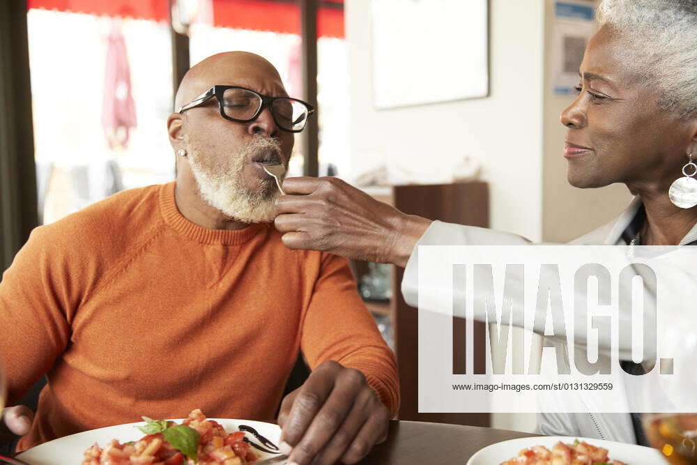Woman feeding man with fork in restaurant model released Symbolfoto property released PMF02052