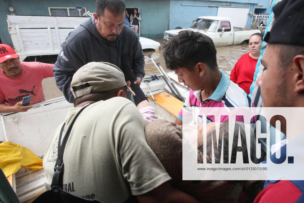 (210904) -- JALISCO, Sept. 4, 2021 -- People help a woman get on a lifeboat on a street flooded due to heavy rains, in the municipality of Tlaquepaque, State of Jalisco, Mexico, on Sept. 3, 2021. A strong storm during the early hours of Friday caused the El Chicharron and Las Pintas dams to overflow, flooding several areas of the municipality of Tlaquepaque. ) MEXICO-JALISCO-FLOOD ArturoxCampos