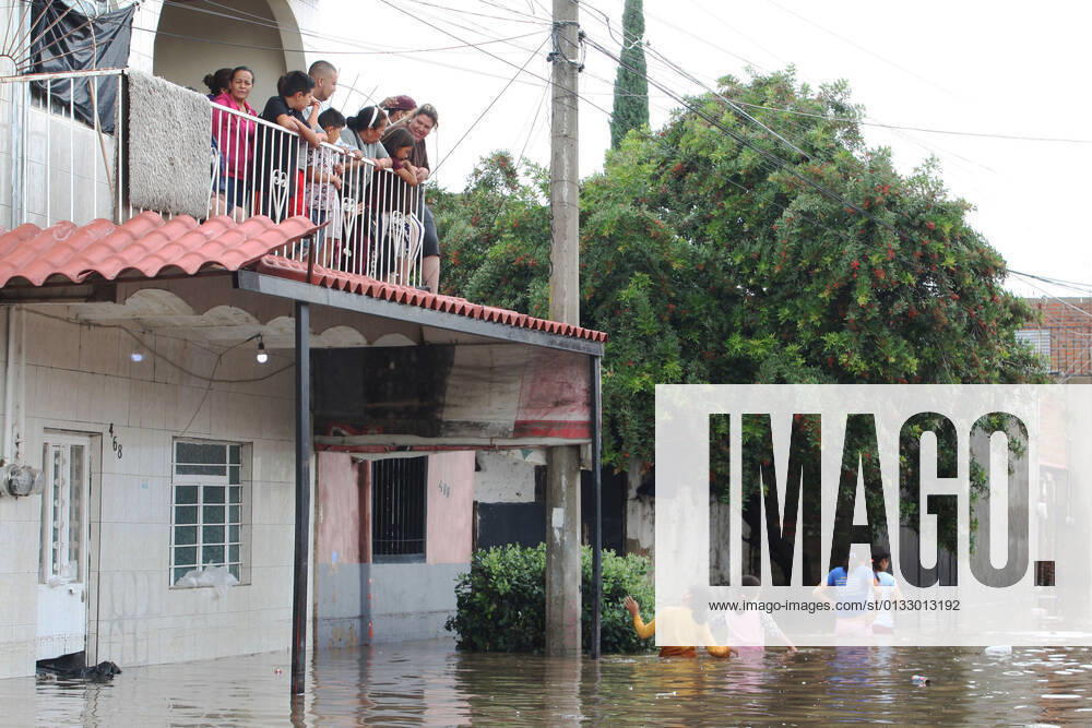 (210904) -- JALISCO, Sept. 4, 2021 -- Girls cross a street flooded due to heavy rains in the municipality of Tlaquepaque, State of Jalisco, Mexico, on Sept. 3, 2021. A strong storm during the early hours of Friday caused the El Chicharron and Las Pintas dams to overflow, flooding several areas of the municipality of Tlaquepaque. ) MEXICO-JALISCO-FLOOD ArturoxCampos