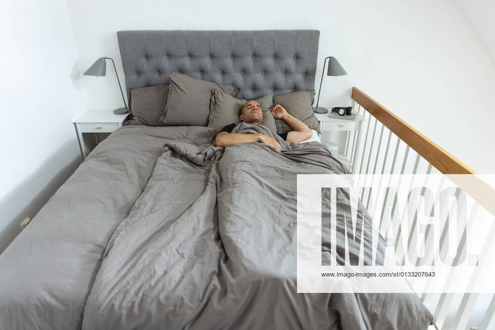 From above of peaceful male lying in soft bed under blanket and sleeping in morning in bedroom FrancisLofvenholm_MorningAtHome_35.jpg