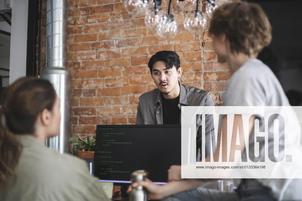 Male computer programmer discussing with female colleagues in office Sweden, Stockholm, model released, property released