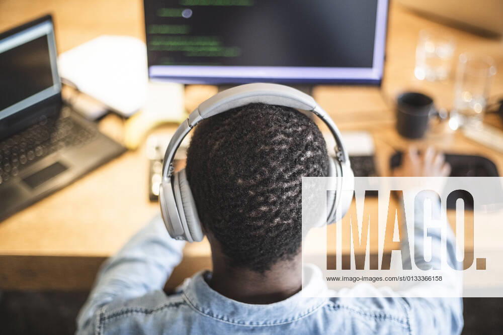 Rear view of male hacker working on computer at office Sweden, Stockholm, model released, property released