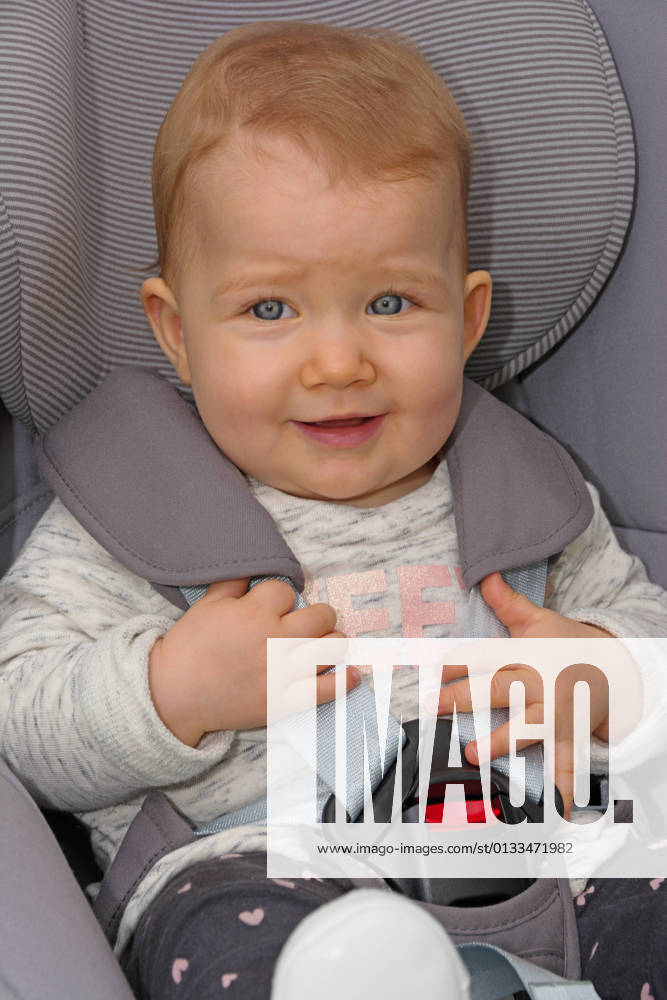 Infant sitting buckled in car seat Baby sitting properly buckled in car seat, portrait format
