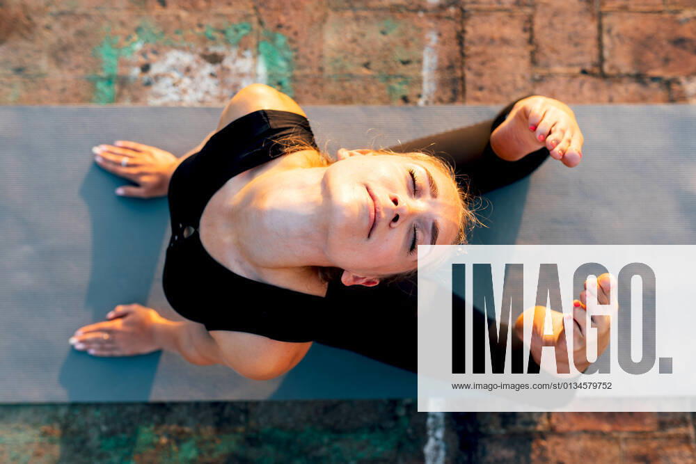 IMAGO Creative, Neujahr, Vorsätze, Sport IMAGO Creative, Jahreszeit Sommer, Sommer in der Stadt IMAGO Creative: Sport in der Stadt IMAGO Creative: Clickbait, Sport und Fitness Young slender female in sports clothes doing Raja Bhujangasana while practicing yoga in city on sunny day, Model released SergioVictorVega_YogaInTheCity_30.jpg