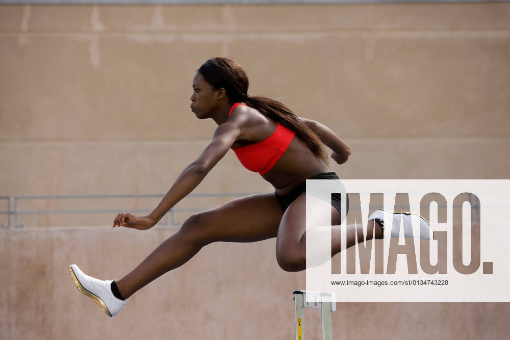 IMAGO Creative: Internationaler Frauenmonat, Mädchen im Sport Runner jumping over hurdles on track, 01.10.2011,