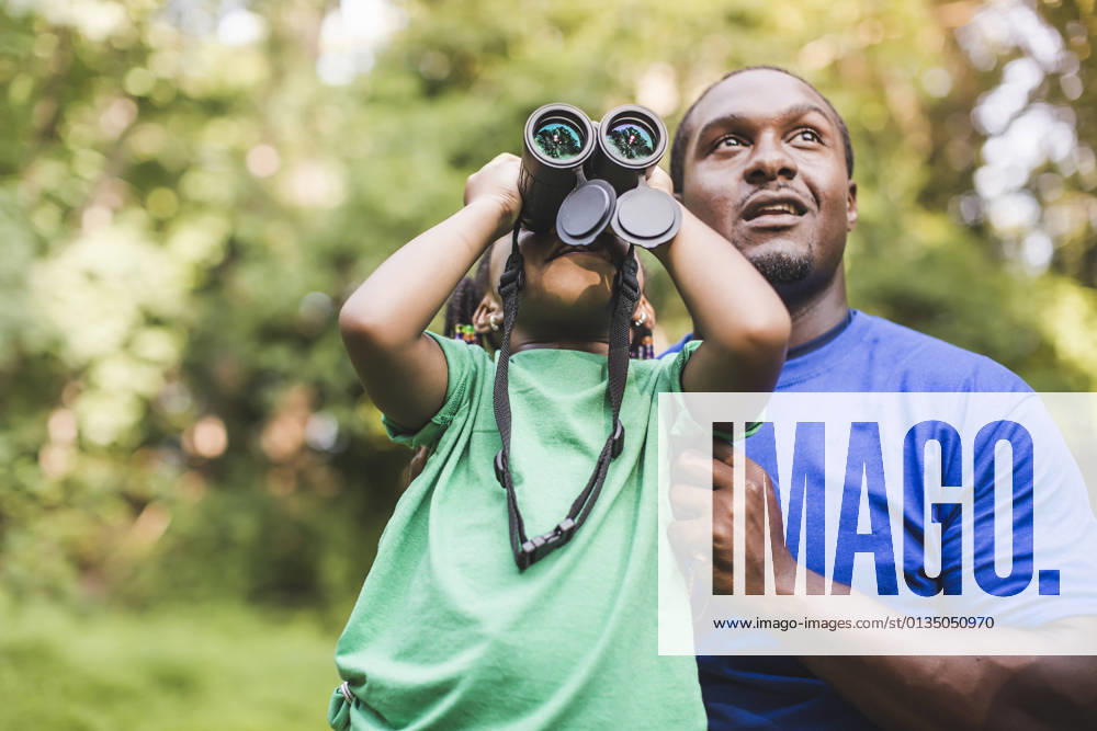 IMAGO Creative: Klimawandel - Umwelterziehung Young father and daughter bird watching in eco forest camp, 01.09.2014,