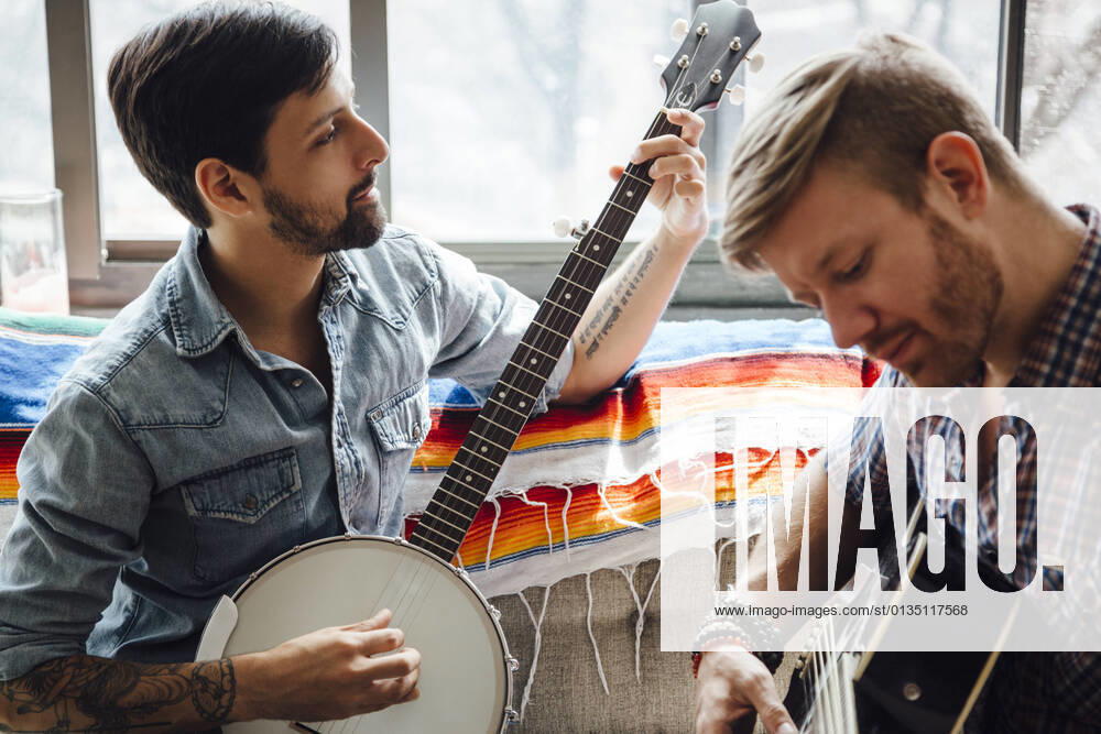 IMAGO Creative: Bildung, Musikerziehung Male couple at home, play guitar and banjo, 17.06.2015,