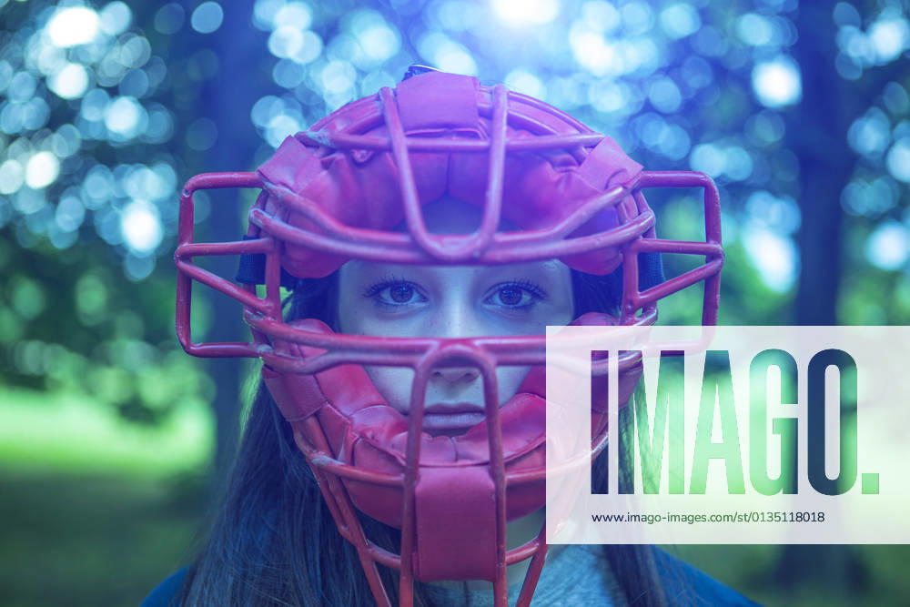 IMAGO Creative: Internationaler Frauenmonat, Mädchen im Sport Portrait of staring teenage girl in park wearing red umpire mask, 17.06.2015,