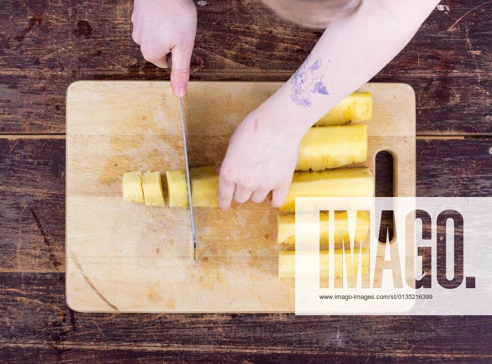 A girl is cutting a pineapple model released, Symbolfoto, 11.10.2020,