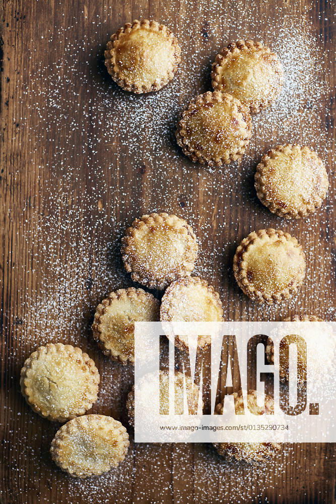 Freshly baked mince pies, dusted with sugar, on wooden counter, overhead view, 28.11.2017,