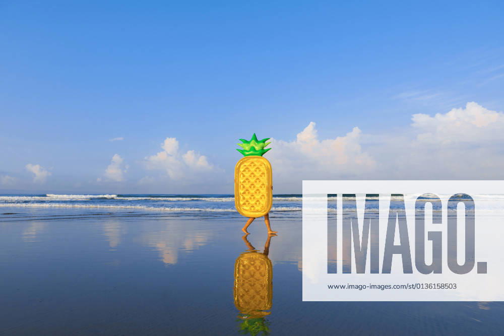 Woman with pineapple float walking at beach model released Symbolfoto EAF00114