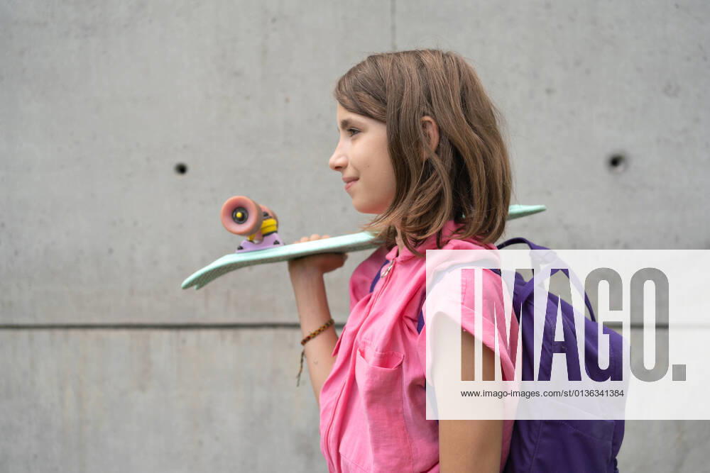 IMAGO Creative: Gesellschaft, Schule, Schulanfang Teenage girl carrying skateboard on shoulder outdoors CR_HABU210902-823115-01 ,model released, Symbolfoto