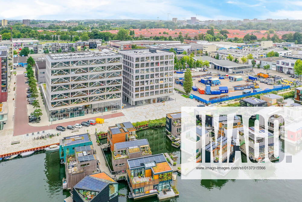 IMAGO Creative, Jahreszeit Sommer, Sommer in der Stadt Drone view of contemporary building facades against pier and houseboats on rippled river in Amsterdam Netherlands CasaMedia_Fonteinkruidstraat56_1.jpg
