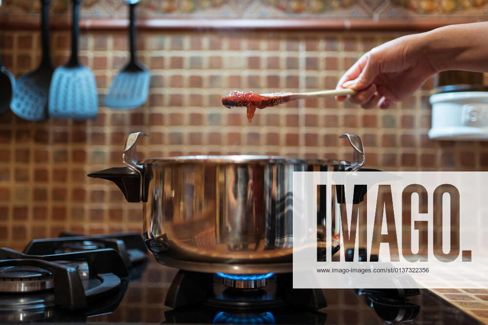 IMAGO Creative, Jahreszeit Sommer, Food, Marmelade kochen Crop anonymous person with delicious fig marmalade on spatula over pressure cooker on gas stove in kitchen, Model released JuanAlbertoRuiz_FigJam_19.jpg