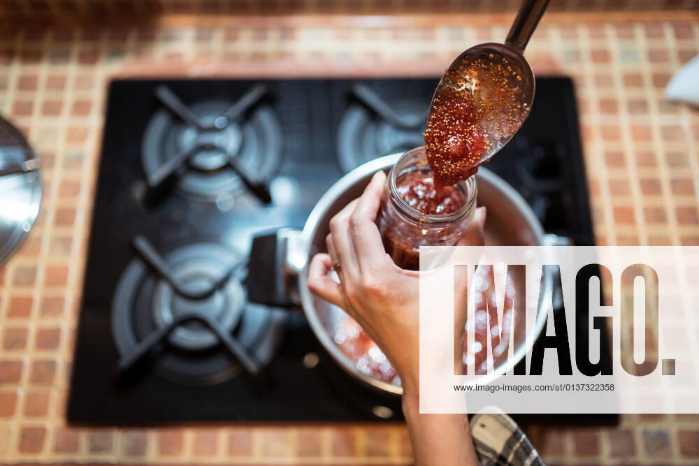 IMAGO Creative, Jahreszeit Sommer, Food, Marmelade kochen High angle of crop anonymous person pouring delicious fig confiture into jar above gas stove at home, Model released JuanAlbertoRuiz_FigJam_20.jpg