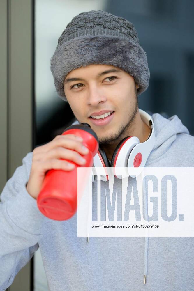 Smiling young latin man drinking water portrait format winter sports training fitness model released, Symbolfoto, 13.10.2020,