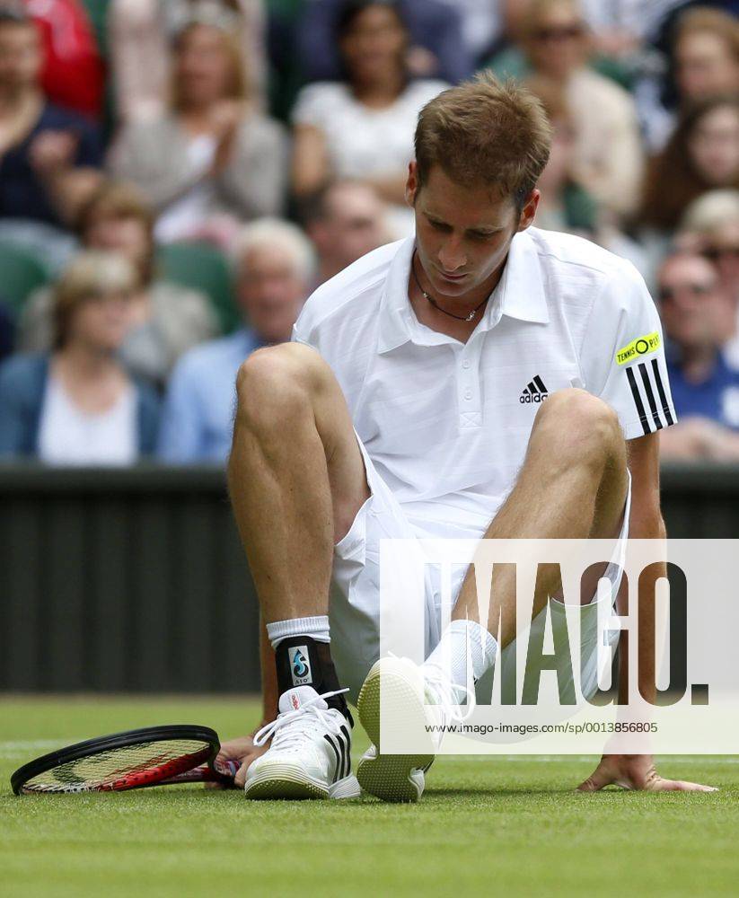 Florian Mayer of Germany falls down during the first round of men s singles on day 2 of the Wimbledon Lawn Tennis Championships at the All England Lawn Tennis and Croquet Club in London, Britain, on June 25, 2013.
