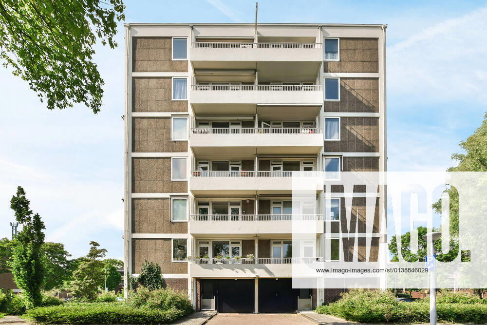 Creative design of masonry multistory building exterior with balconies between overgrown trees under light sky in Amsterdam North Holland, Property released CasaMedia_VanBoshuizenstraat465_3.jpg