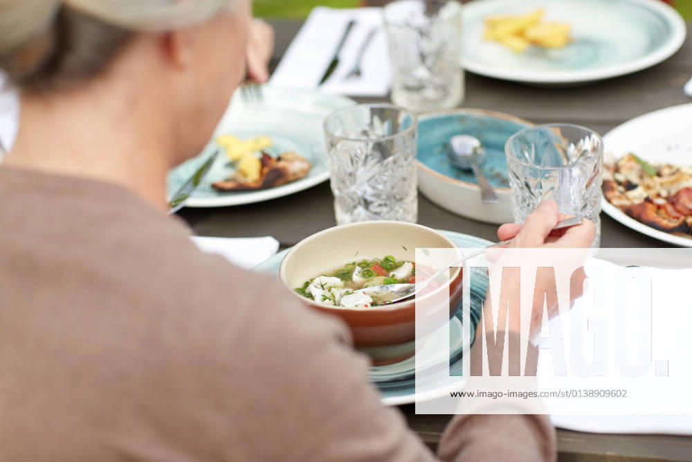 Close up of woman eating soup in summer garden family, home, dinner, holidays and people concept - close up of woman eating soup in summer garden