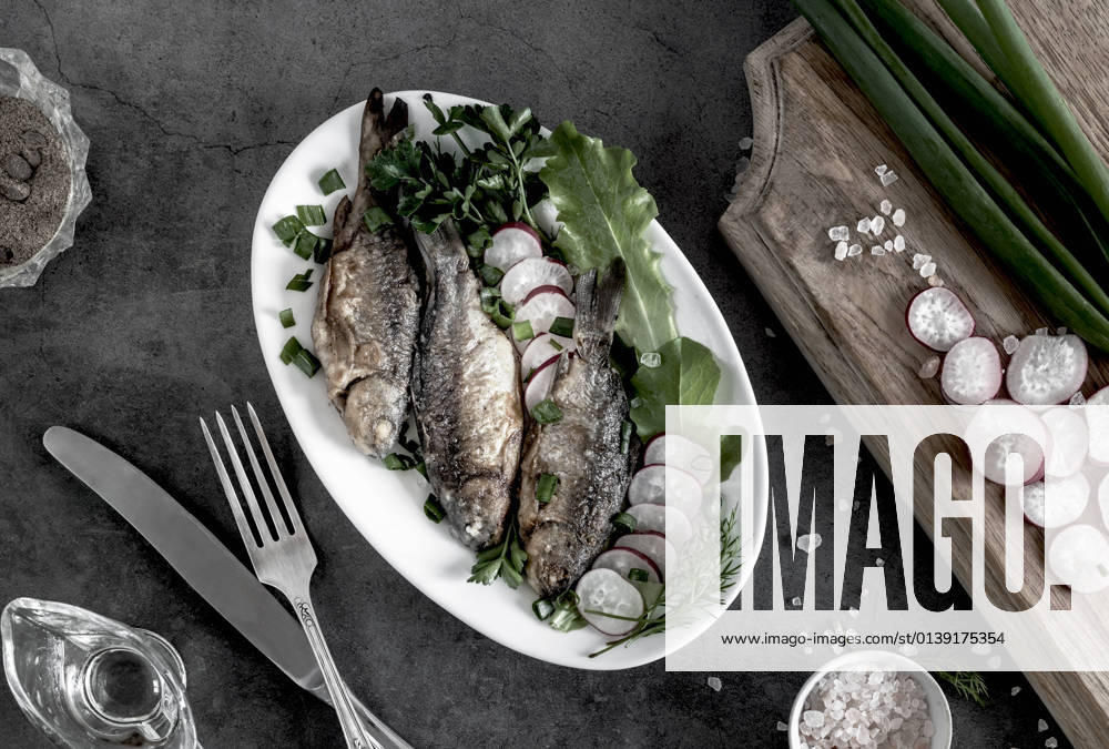 IMAGO Creative, Food, Karpfen-Saison Fried crucian carp on a plate with vegetables On the plate are fried crucian carp, radishes , green onions and lettuce. Top view, close-up.