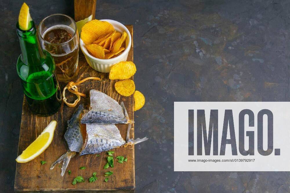 IMAGO Creative, Food, Karpfen-Saison Dried bream in form butterfly with beer, lemon and potato chips on dark wooden board. Snack on fish with beer. Top views with clear space, 14.10.2020,