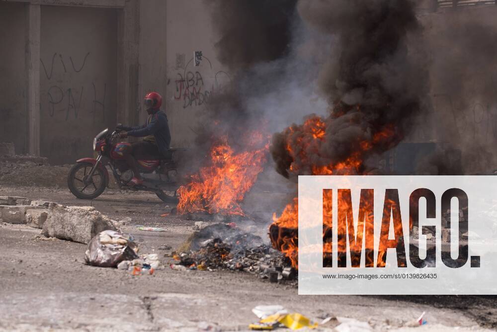 A man on a motorcycle passes burning barricades during a day of protests following the kidnapping of 17 foreign missionaries, 16 of them American and one Canadian, which occurred last Saturday when they were returning from an orphanage on the outskirts of the capital, in Port-au-Prince, Haiti, 23 October 2021. A week after the kidnapping the 17 people, neither the Haitian Government nor the Police have offered official information on the case, although several sources from the Executive have confirmed to the media that the detained missionaries are being held by the 400 Mawozo gang, which is asking for a ransom of 17 million dollars. In recent months, murders, robberies and kidnappings have multiplied, becoming a lucrative source of funding