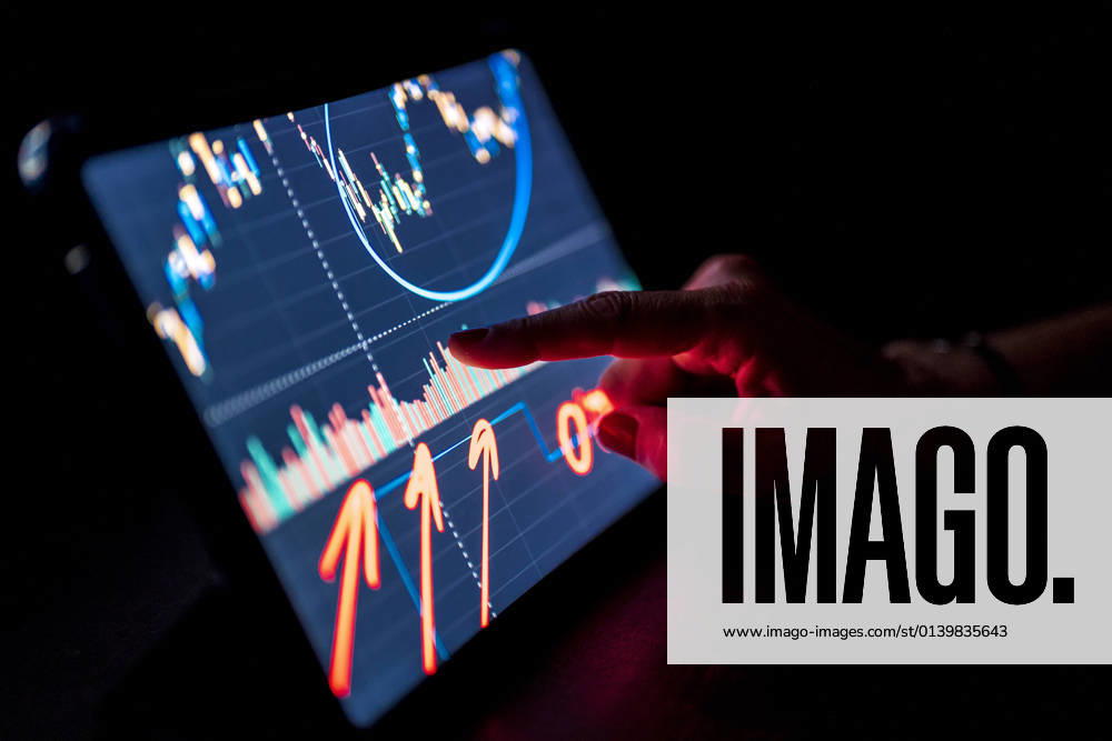 IMAGO Creative: Corporate: Klimaschutz, Digitalisierung und Urbanisierung Businesswoman pointing at stock market data on digital tablet model released Symbolfoto property released DLTSF02230
