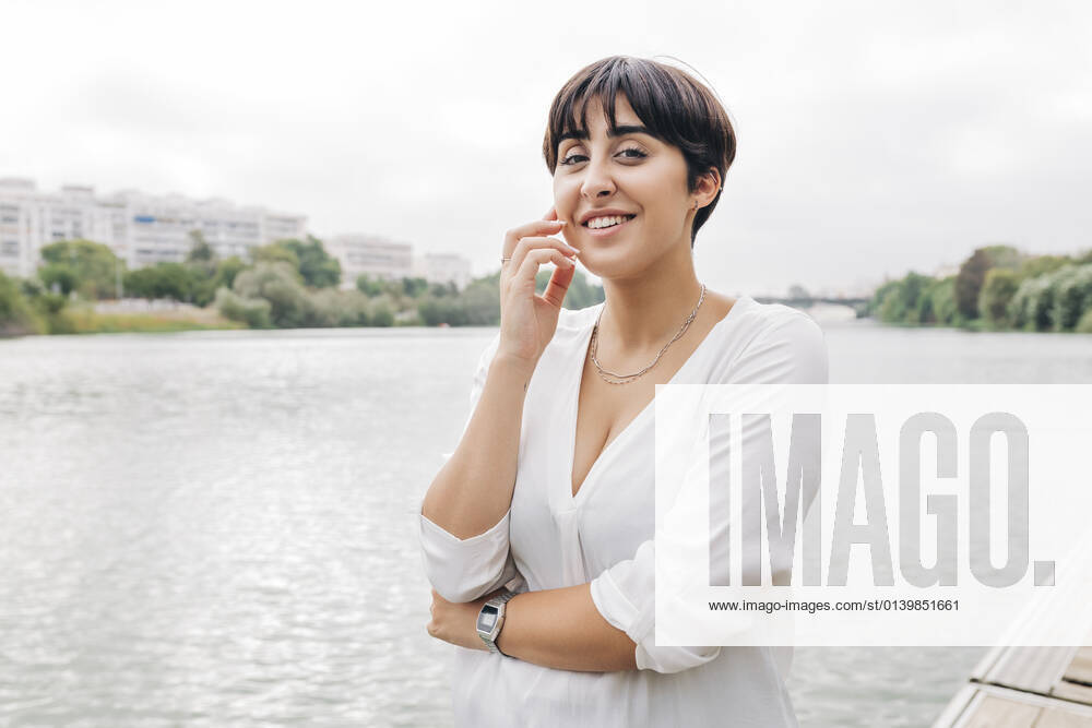 Beautiful woman with short hair standing by lake model released Symbolfoto JRVF01962