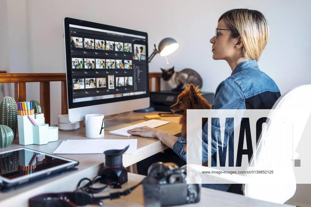 Female vlogger using computer during video conference in living room model released Symbolfoto property released JSRF01629