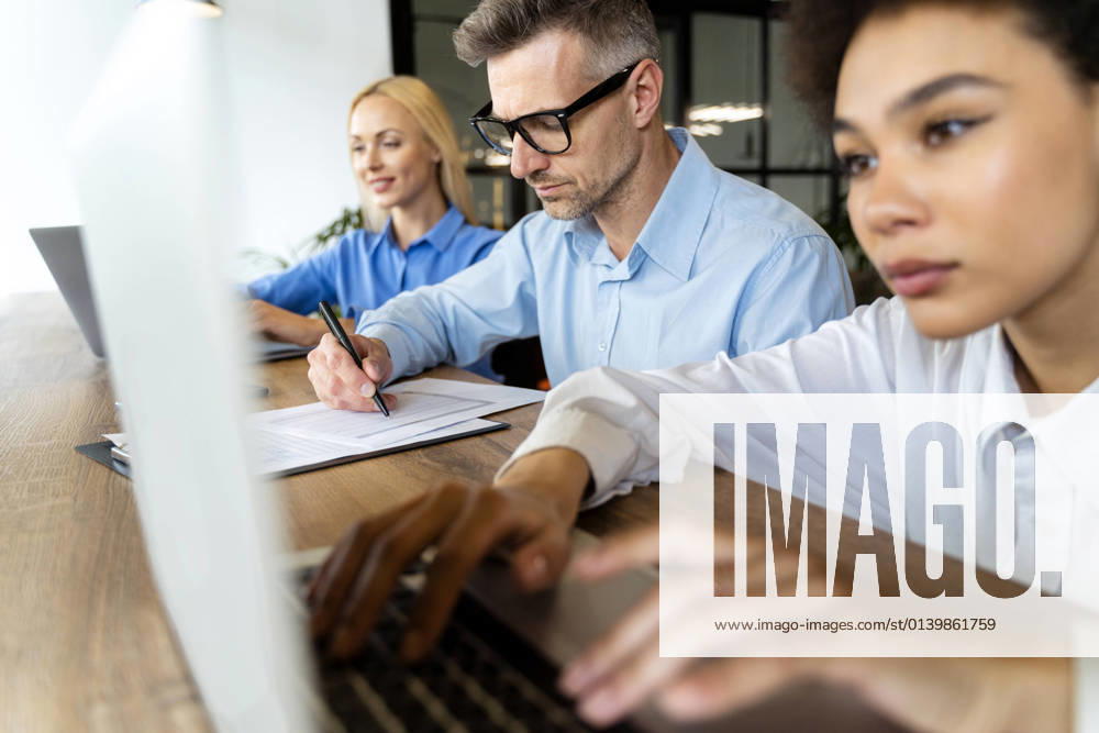 Businessman working with female workers in office model released Symbolfoto property released OIPF01121