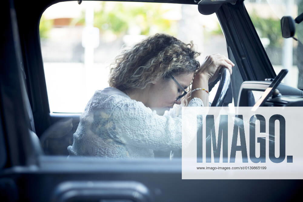 IMAGO Creative, Gesellschaft, Leisure Sickness Tired mature woman with curly hair sitting in car model released Symbolfoto SIPF02413