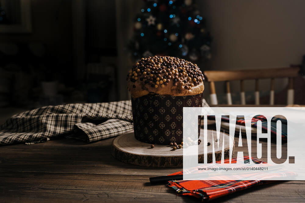 Sweet homemade baked panettone on round wooden stand near knife for celebrating Christmas JayMid_XmasPanettone_1.jpg