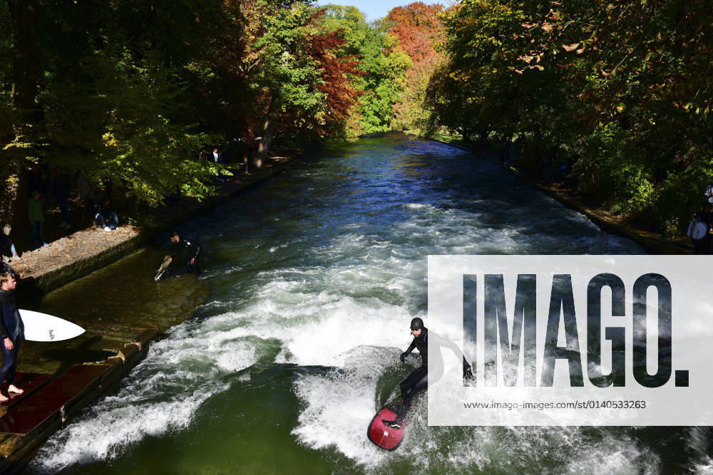 Autumn presents the English Garden in Munich on Wednesday 27 10 2021 The autumn has colored the trees, in glorious sunshine the park attracts many people A crowd puller is the standing wave in the Eisbach, a paradise for surfers in the middle of the city