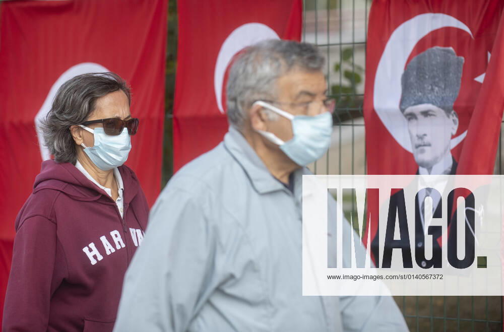 People wearing face masks walk on a street, in front of Tukey s flag on Oct. 29, 2021. Turkey confirmed 24,409 new COVID-19 cases, raising its tally of infections to 7,985,944, according to its health ministry. Some 209 persons died of Covid-9 today, increasing the death toll from the virus in Turkey to 70,207. (