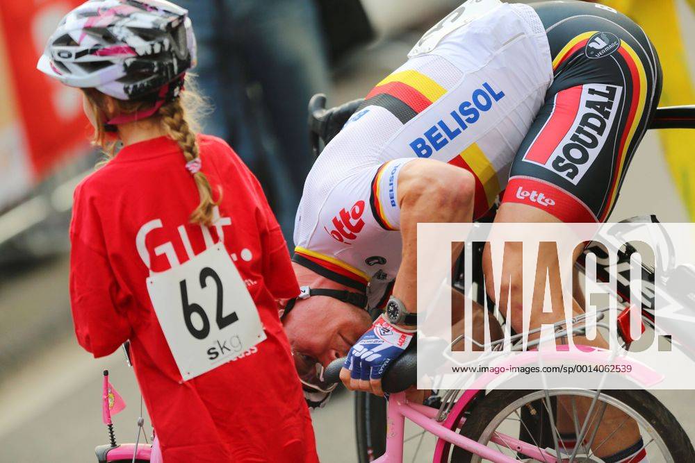 Radrennen Tour de Neuss am Mittwoch, 24. Juli 2013 auf einem Rundkurs in der Innenstadt von Neuss. Sieger Andre Greipel ( GER Team Lotto Belisol ) repariert das Fahrrad eines kleinen Mädchens