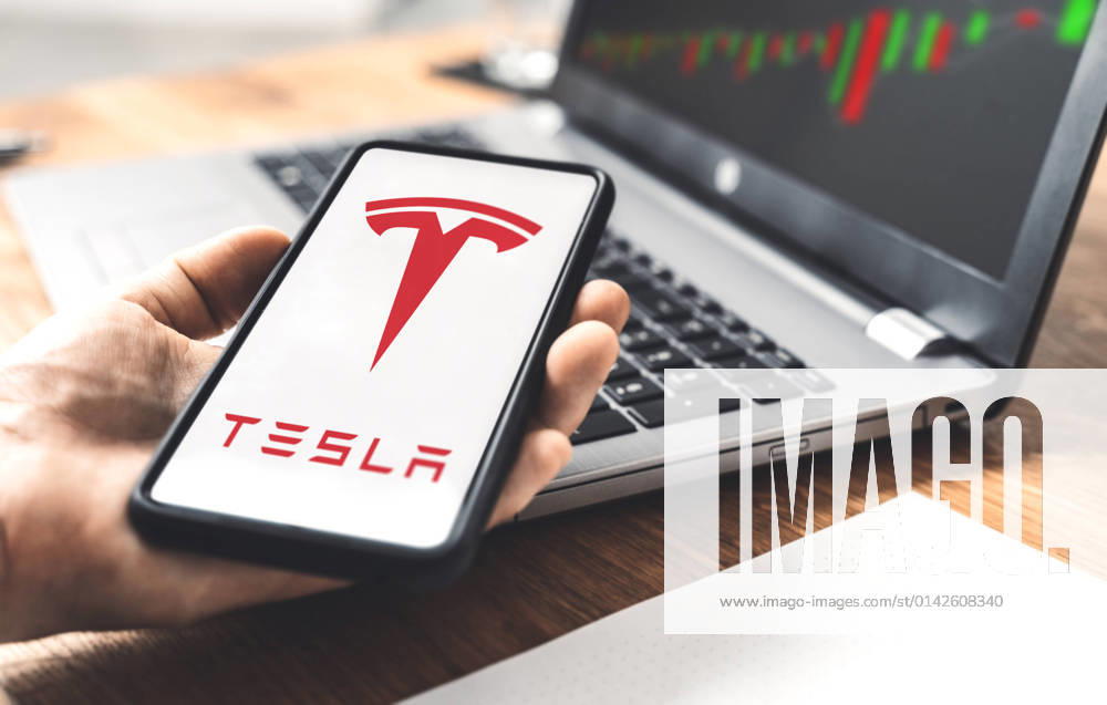 Tesla car electric car logo on a smartphone, trading on the stock exchange with shares of Tesla stock by CEO Elon Musk, online trading with shares