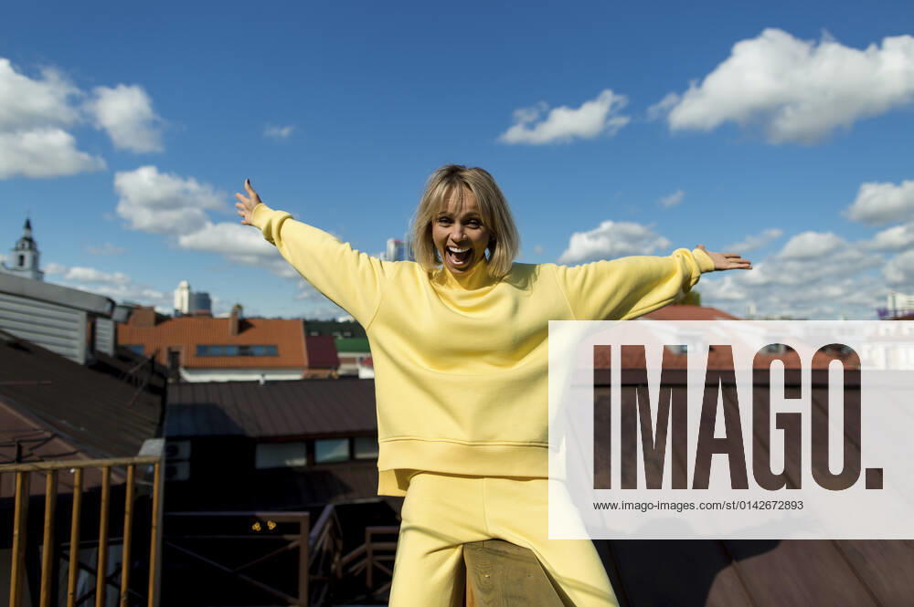 Cheerful woman with arms outstretched enjoying on rooftop model released, LLUF00162