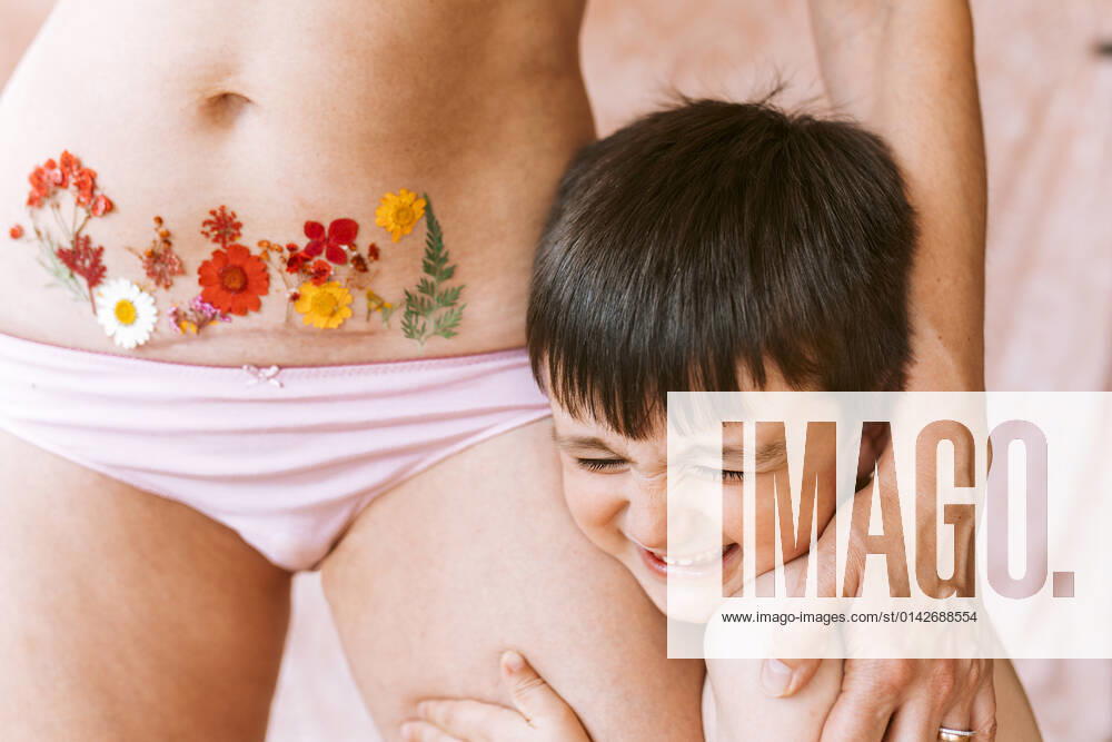 Happy son embracing mother with flower tattoo on Caesarean scar model released, EGHF00257