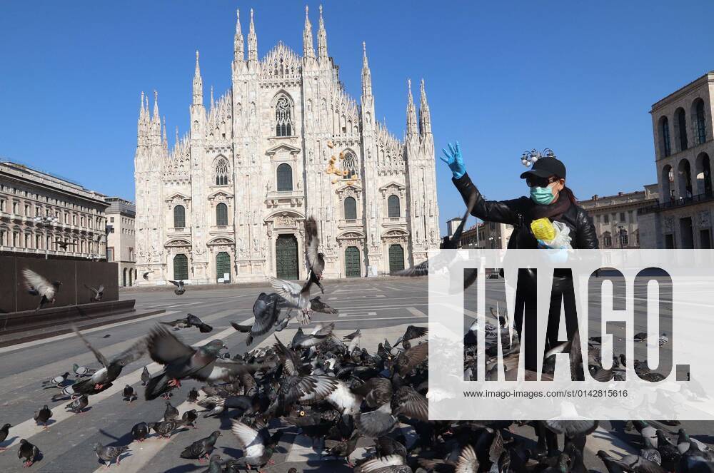 Photo ipp giorgio rossi milan 10 04 2020 coronavirus emergency piazza duomo deserted and pigeons are fed by a girl with a mask coronavirus emergency piazza du 0