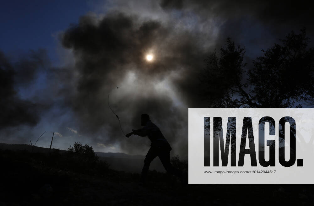 (211126) -- NABLUS, Nov. 26, 2021 -- A protester uses a slingshot to hurl a stone at Israeli soldiers in a protest against the expansion of Jewish settlements in the village of Beita, south of the West Bank city of Nablus, Nov. 26, 2021. (Photo by Ayman Nobani Xinhua) MIDEAST-NABLUS-CLASHES ChenxLin