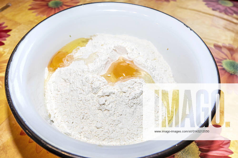 Baking ingredients for Stollen in a white enamel bowl ,candied lemon peel, candied orange peel, almonds, butter, eggs, flour 1049002936