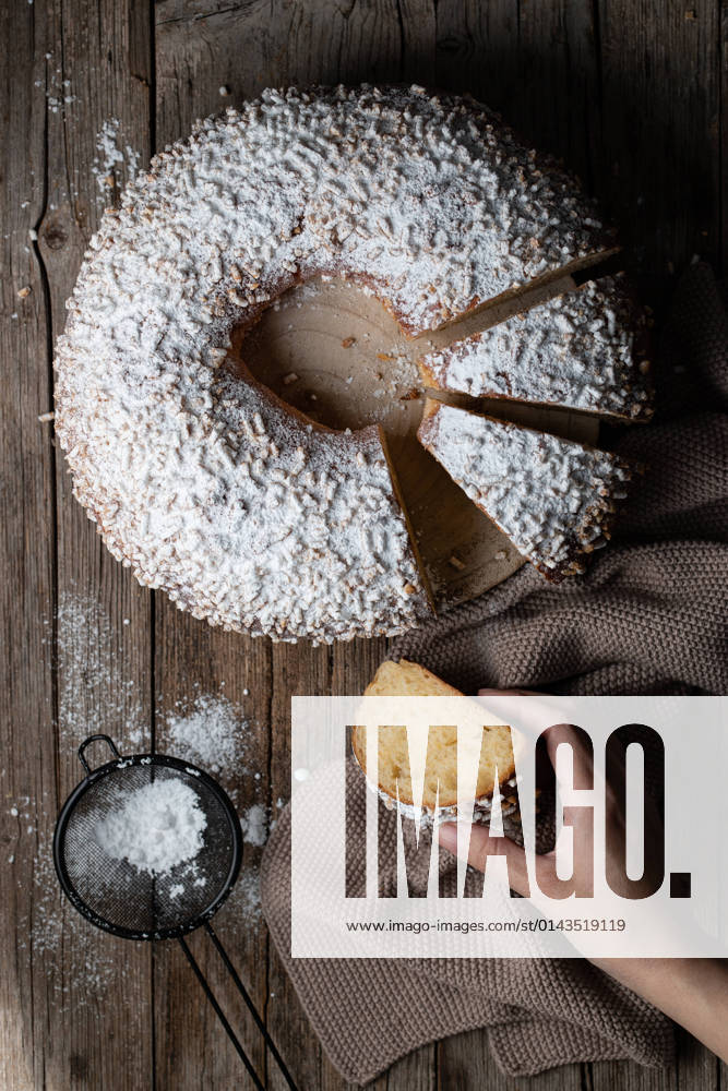 Top view of crop person taking slice of king s cake dusted with powdered sugar and located on wooden table PimientaDulce_RosconOfKings_7.jpg