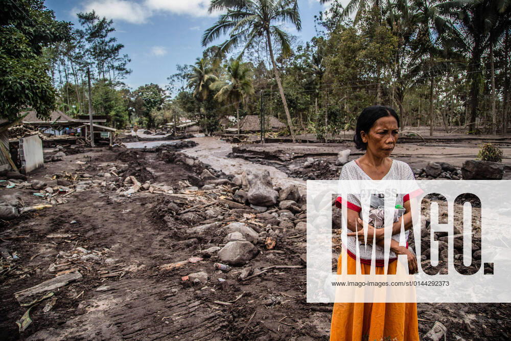 A woman looks at her house that was buried by volcanic ash in Kamar Kajang, Lumajang. At least 14 people are dead and dozens are injured after Mount Semeru, a volcano in Indonesia s East Java province, erupted on Saturday, throwing towers of ash and hot clouds that covered nearby villages. Kamar Kajang Indonesia - ZUMAs197 20211209_zaa_s197_005