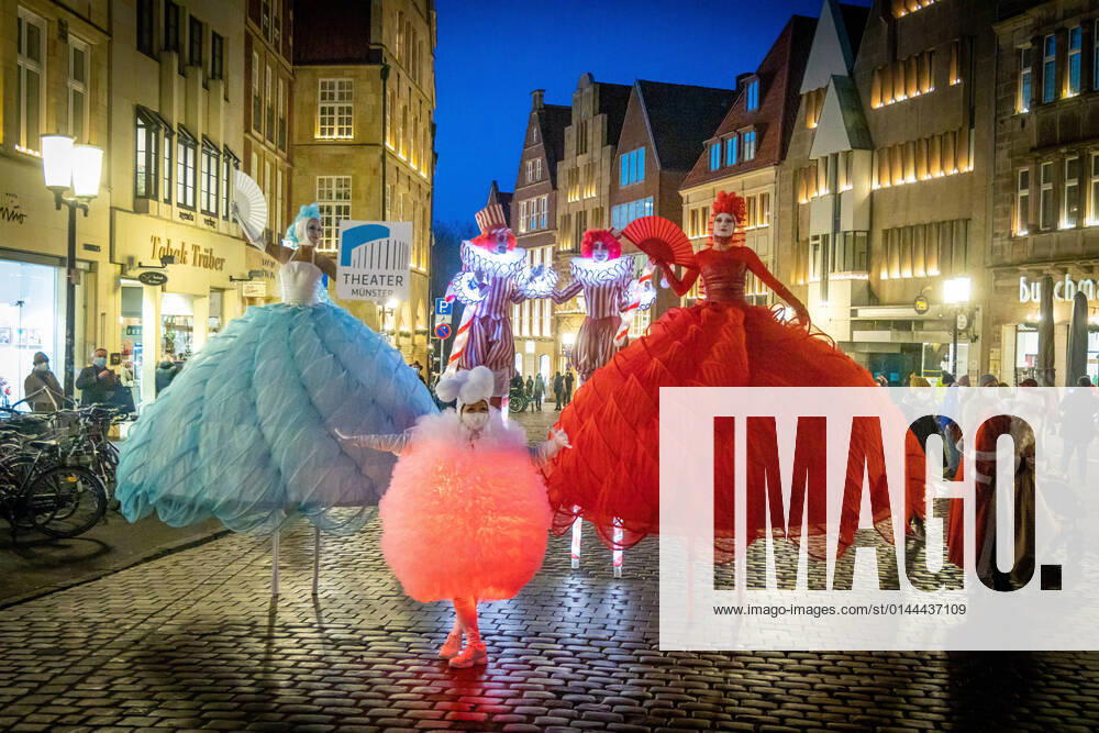 Advertising campaign of the Theater Münster in the city centre of Münster DEU, Germany, North Rhine Westphalia, Münster, 10 12 2021 Stilt walkers in colourful fantasy costumes Members of the Berlin Dulce Compania run advertising for the theatre programme of the 2021 2022 season of the Theater Münster