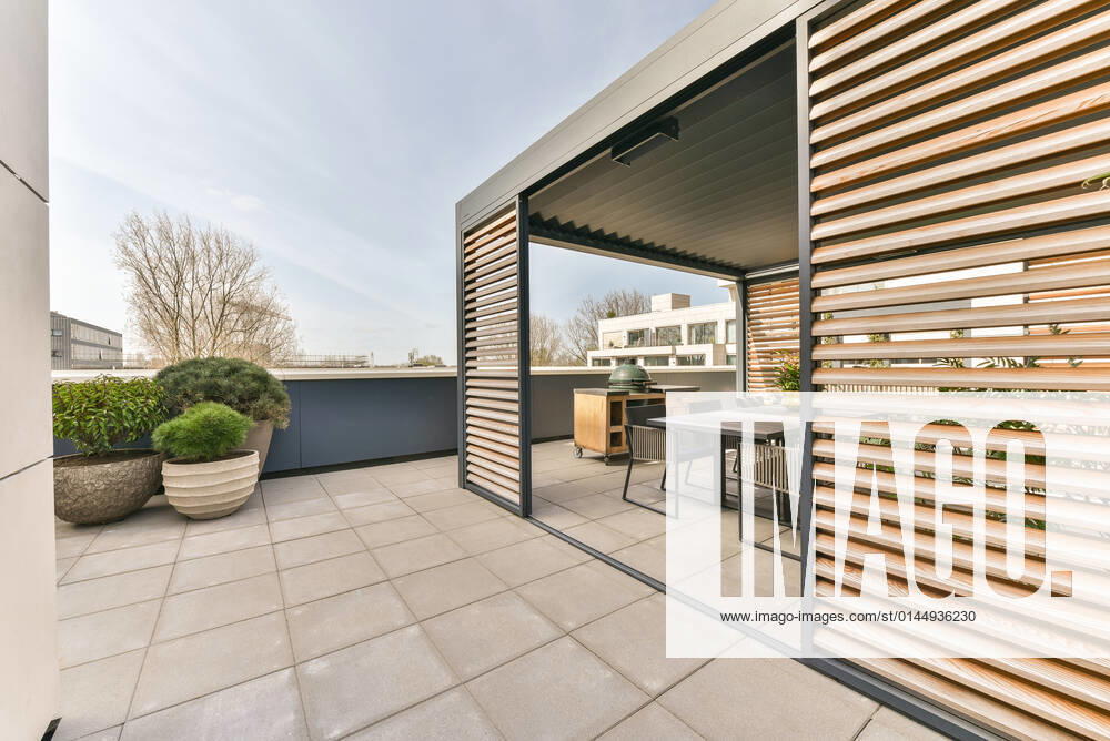 Exterior of spacious modern terrace with dining table with chairs placed near grill under roof CasaMedia_FredRoeskestraat88A9_41.jpg